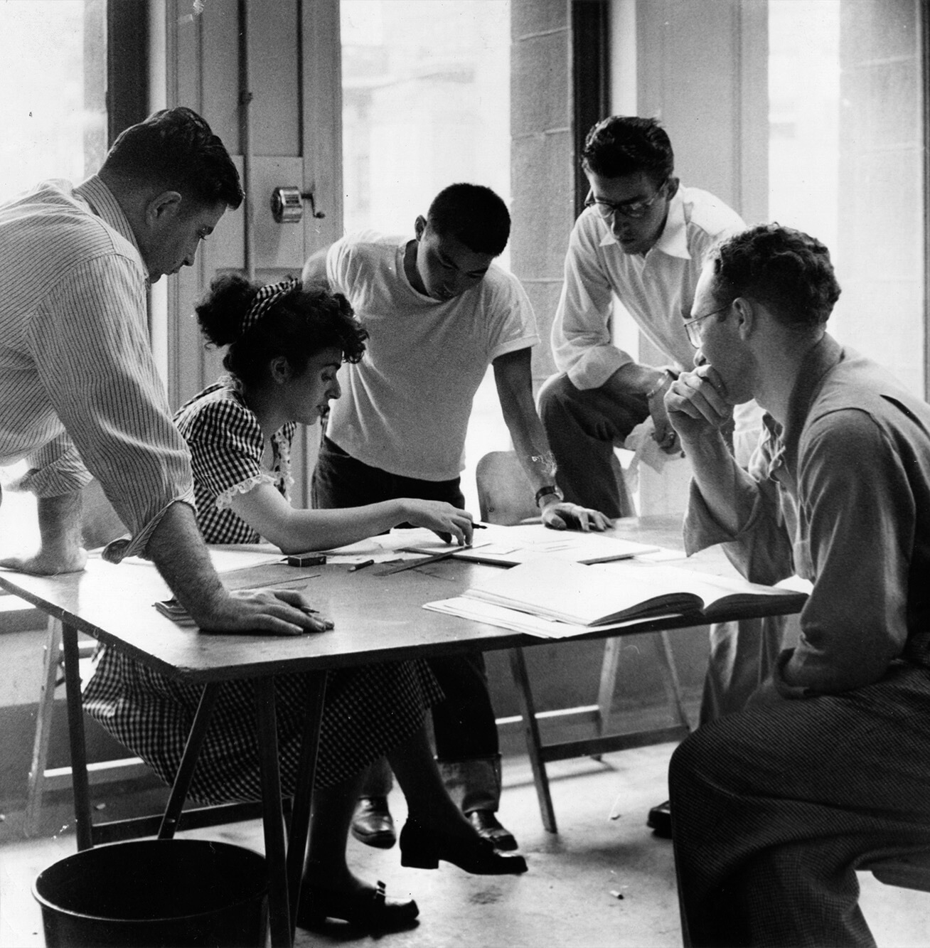 Historic black and white photo of students working at a table at ID