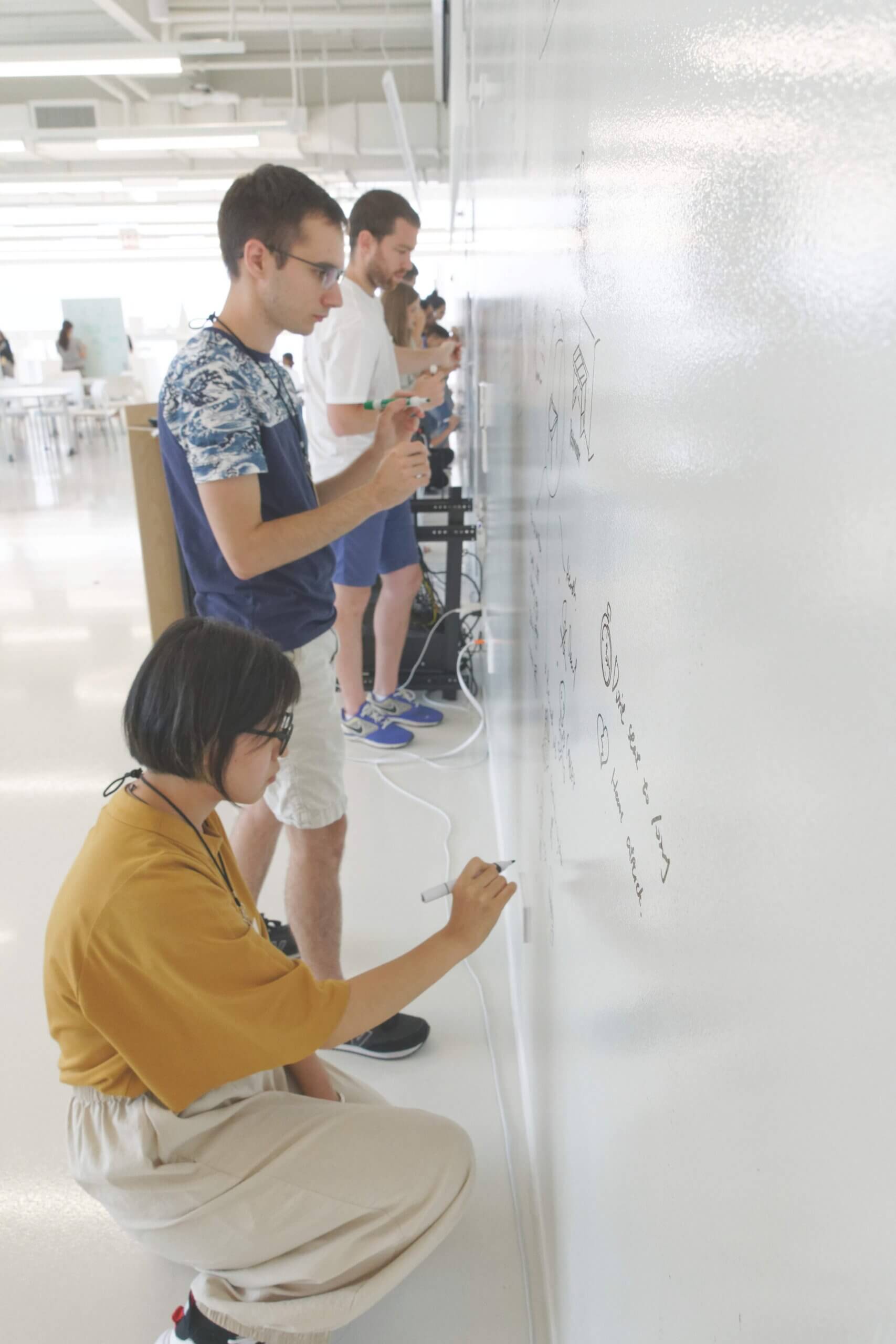 A photo of students at a whiteboard in college.