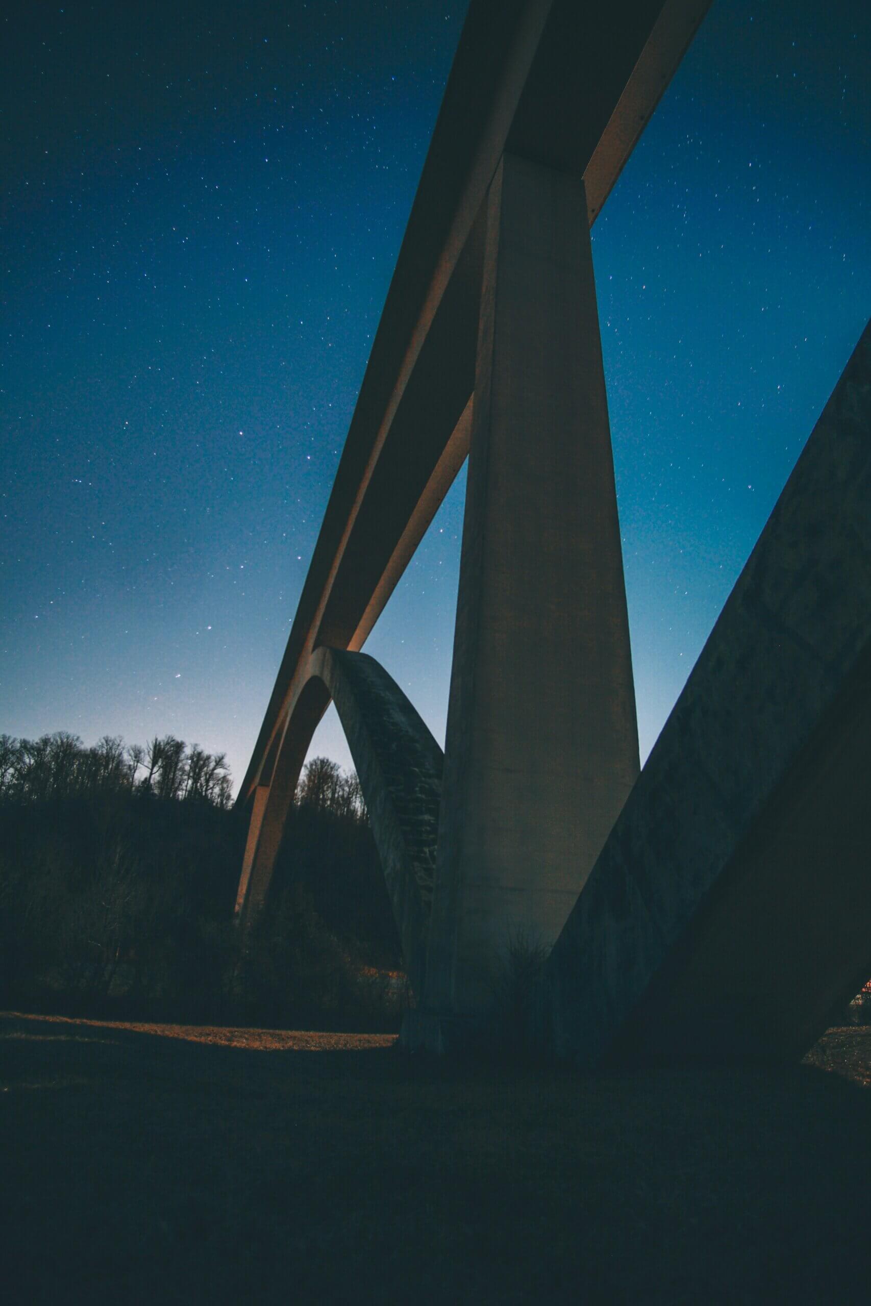 A photo of a modern bridge under a starry night sky.